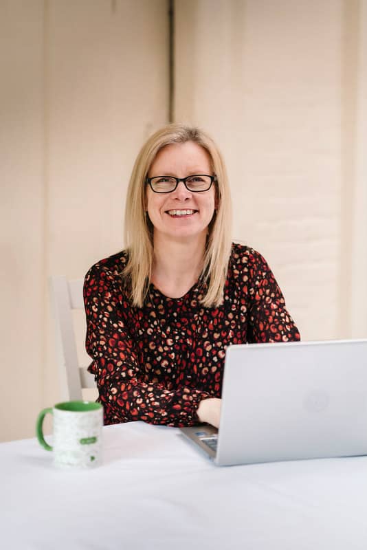 Katherine Atreed of Atkat Marketing working at a desk smiling 